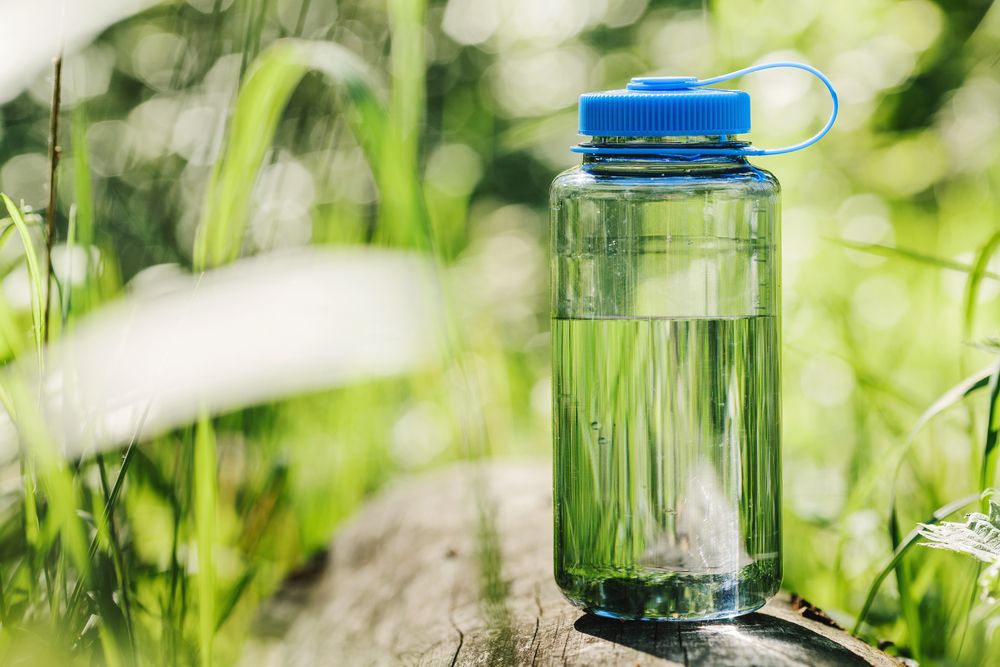 Water bottle on wood with summer scene background