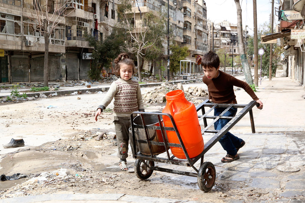 Поход за водой на разбомбленной улице в Алеппо, Сирия