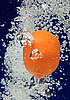 Апельсин (мандарин) падает в синюю воду | Фото